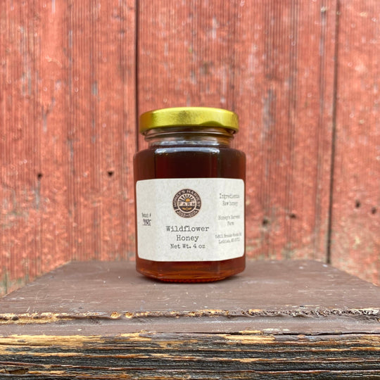 Jar of honey on a wooden surface with a rustic wooden background