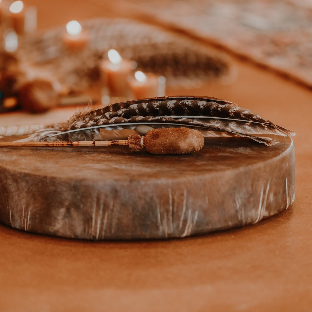 Leather drum with feathers on a warm-toned background