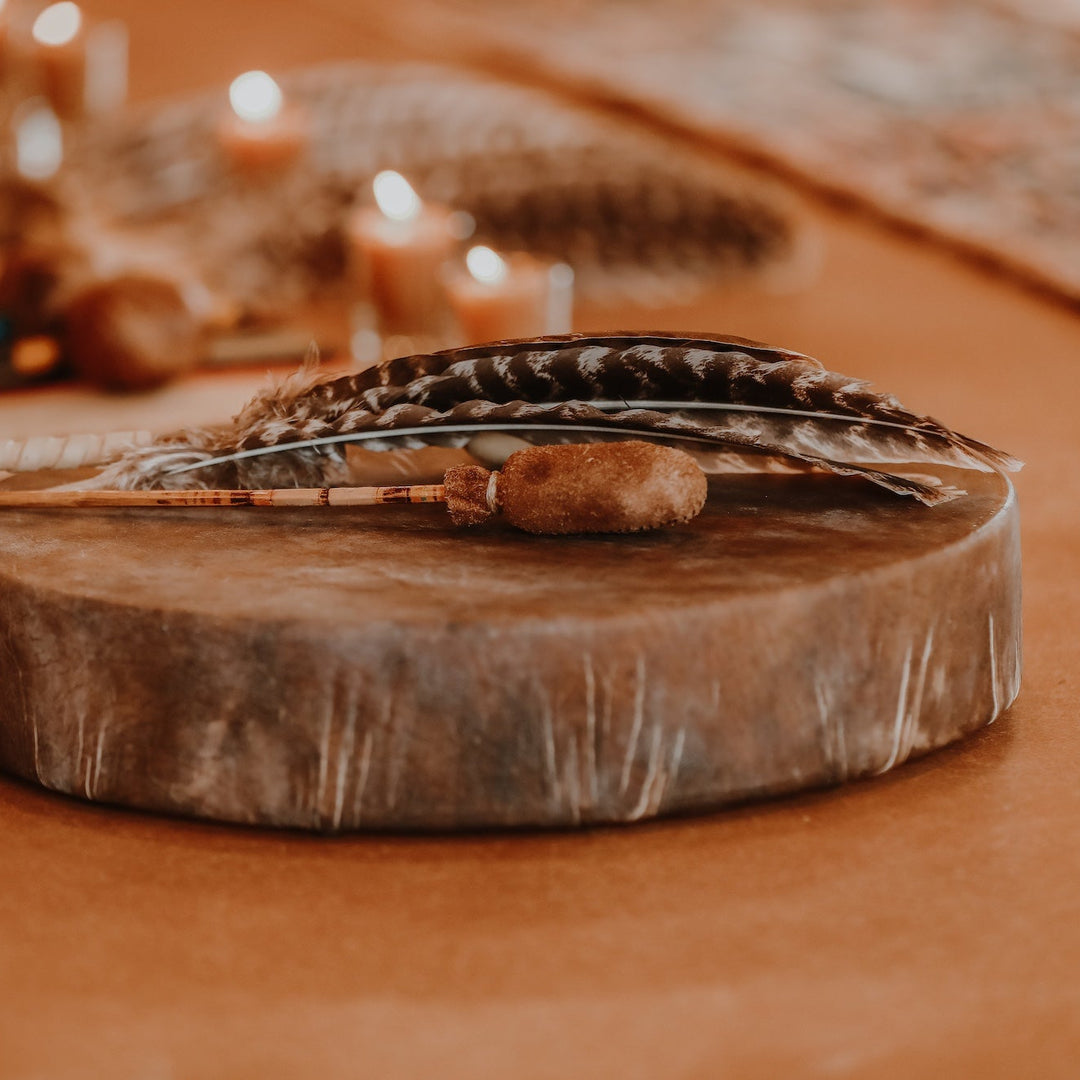Leather drum with feathers on a warm-toned background