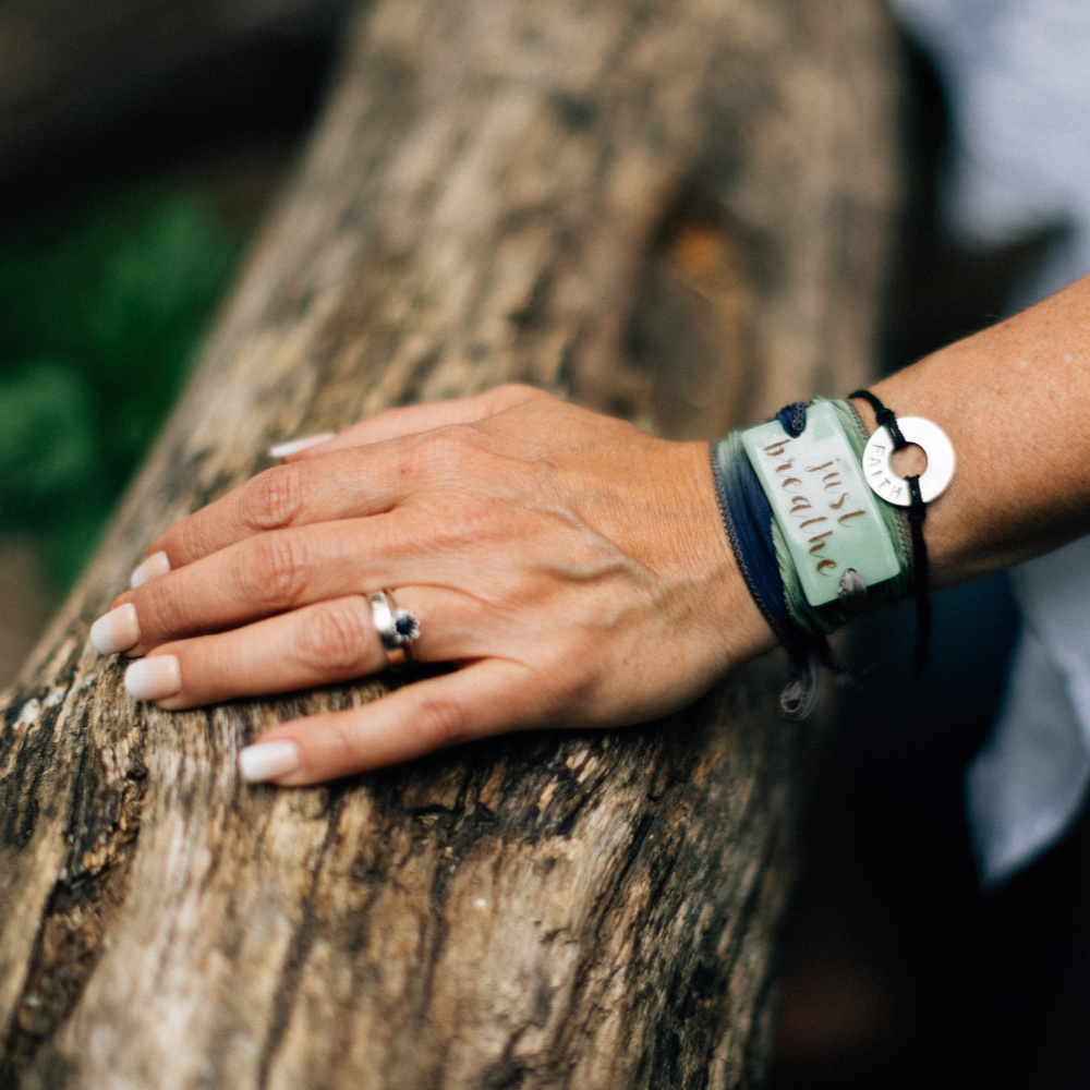 Hand with a ring and bracelets on a wooden surface