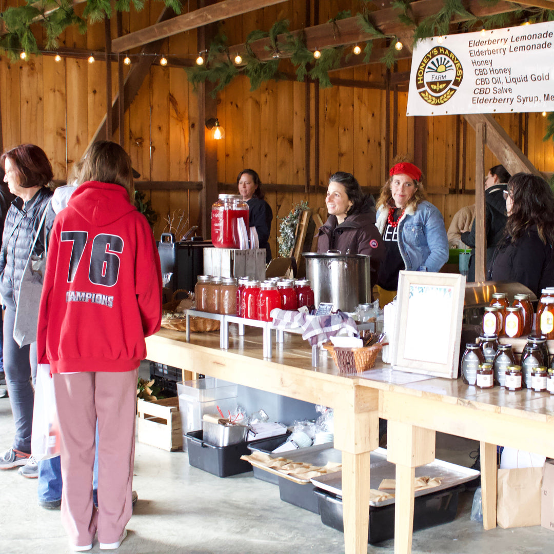 People gathered around a wooden table with food and drinks in a rustic indoor setting.