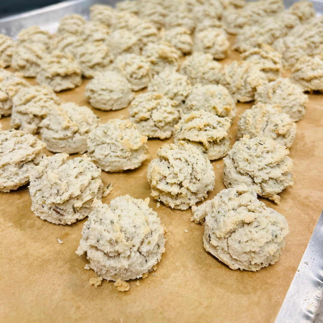 Gluten free biscuits on a baking sheet lined with parchment paper
