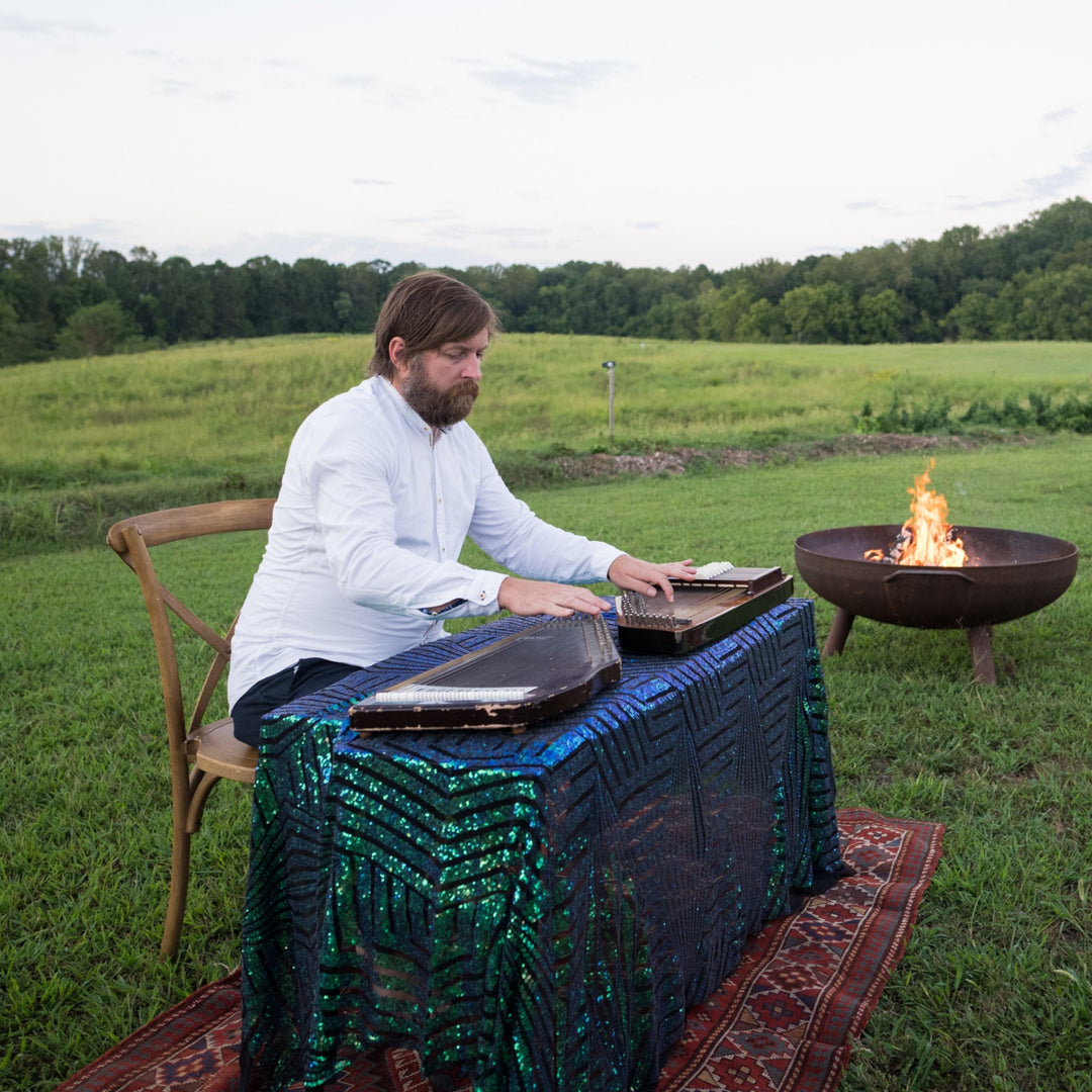 Person sitting at a table with electronic devices in a scenic outdoor setting