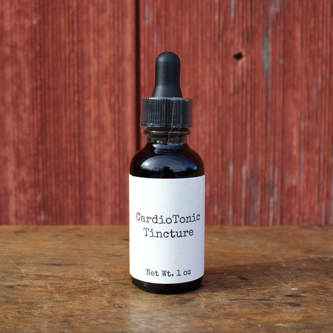 Bottle of CardioTonic Tincture on a wooden surface with a red wooden panel background