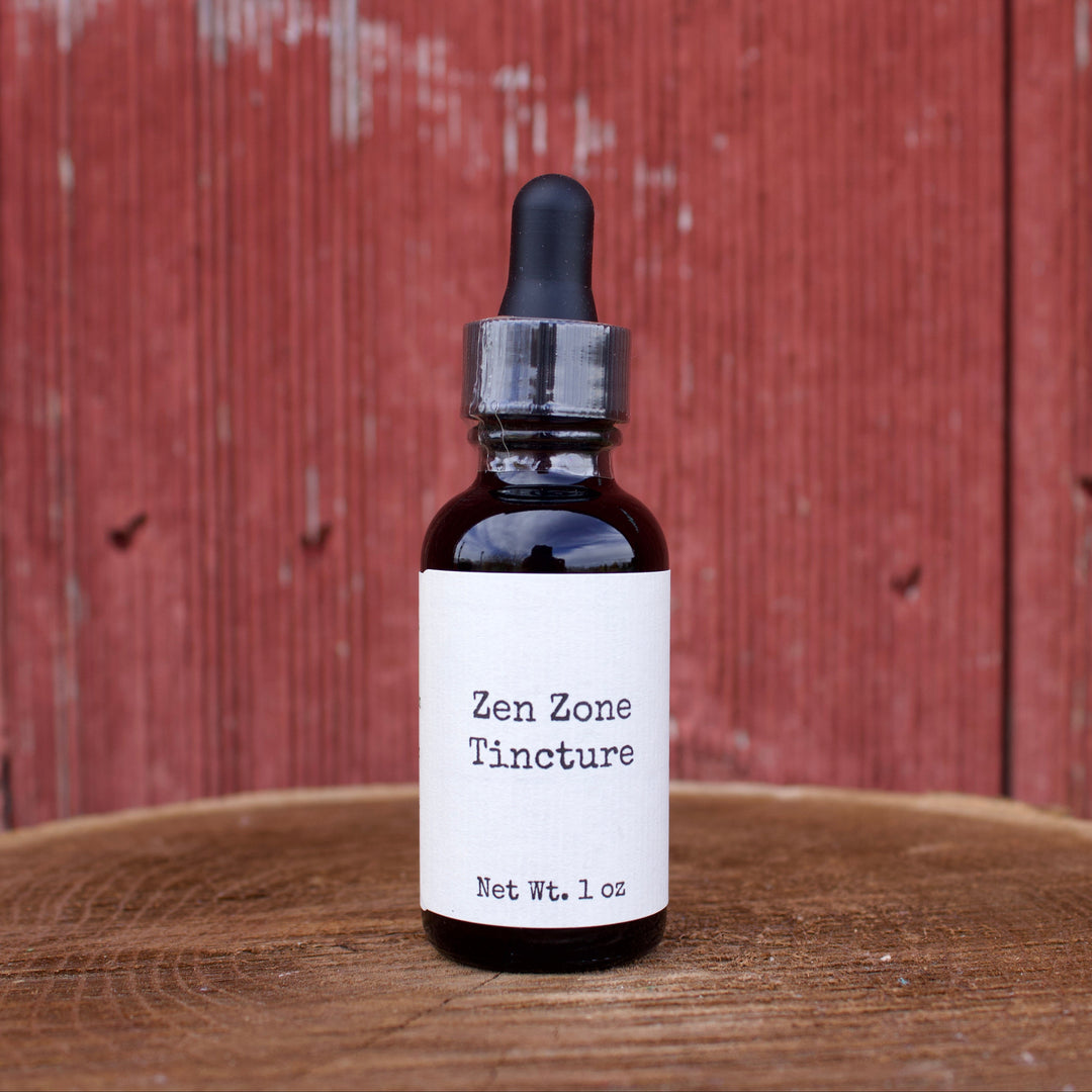 Bottle of Zen Zone Tincture on a wooden surface with a red wooden background