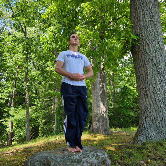 Man standing barefoot in a rock in the forest