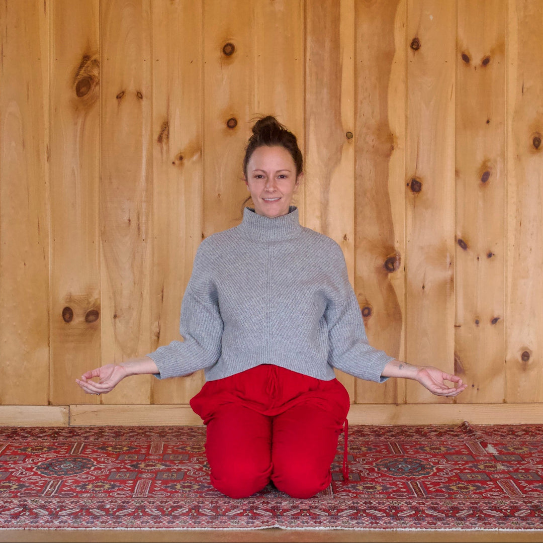 Woman kneeling in a wooden room