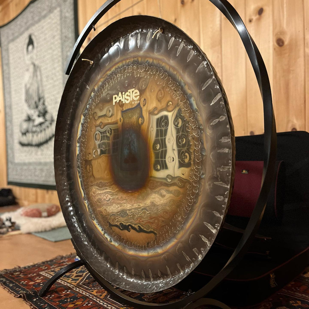 Gong on a stand with a wooden wall and rug in the background
