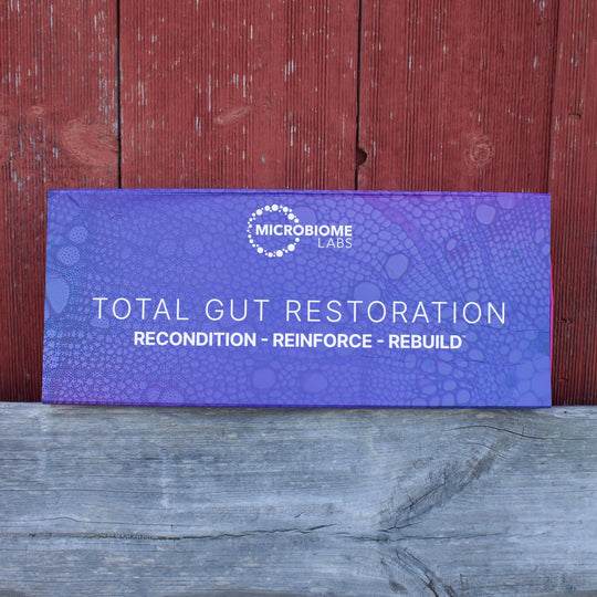 Purple box labeled 'Total Gut Restoration' on a wooden surface