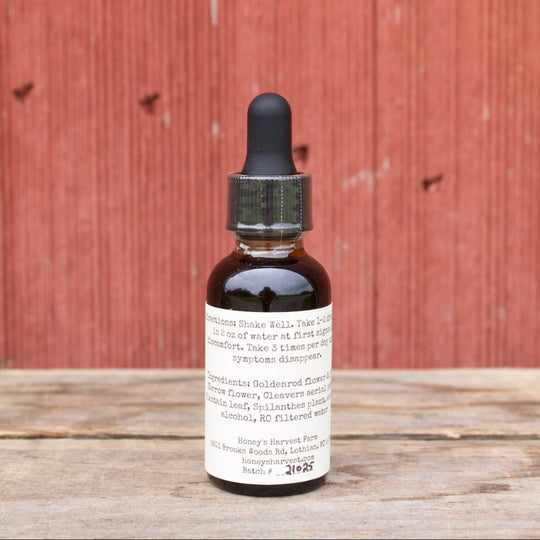 Bottle of tincture on a wooden surface with a red wooden background